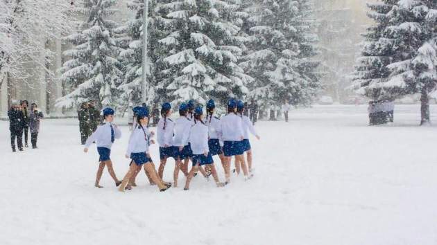Согревались песнями и маршем: в России школьников в летней одежде вывели на снег. Фото