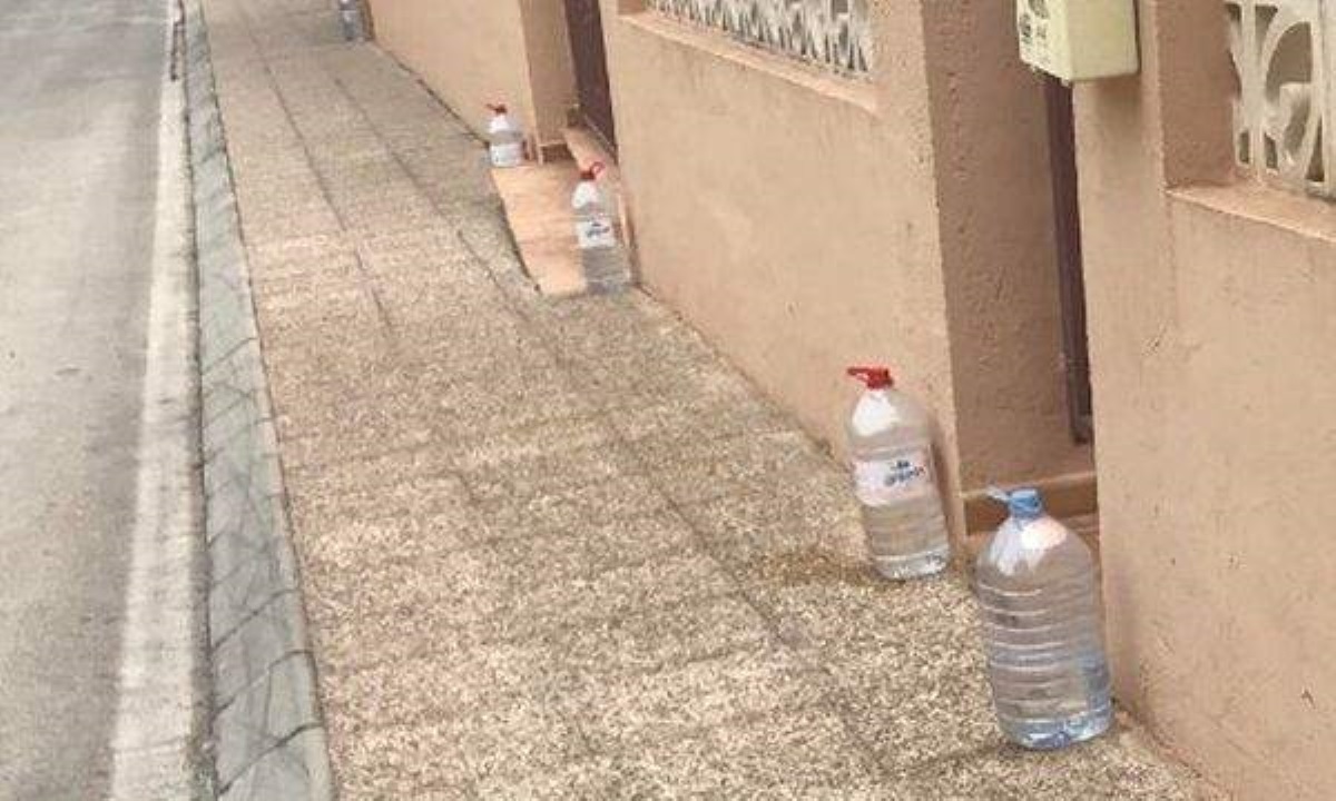 Бутылки с водой у домов помогают испанцам сохранять чистоту